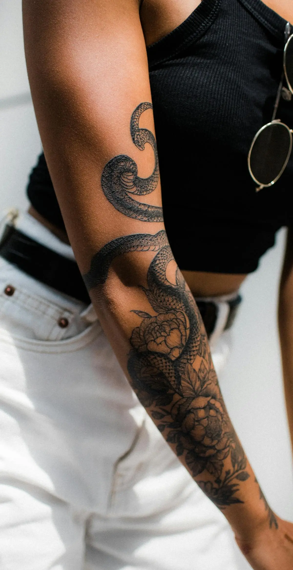 Black-and-grey snake and peony forearm piece shaded entirely in grey
