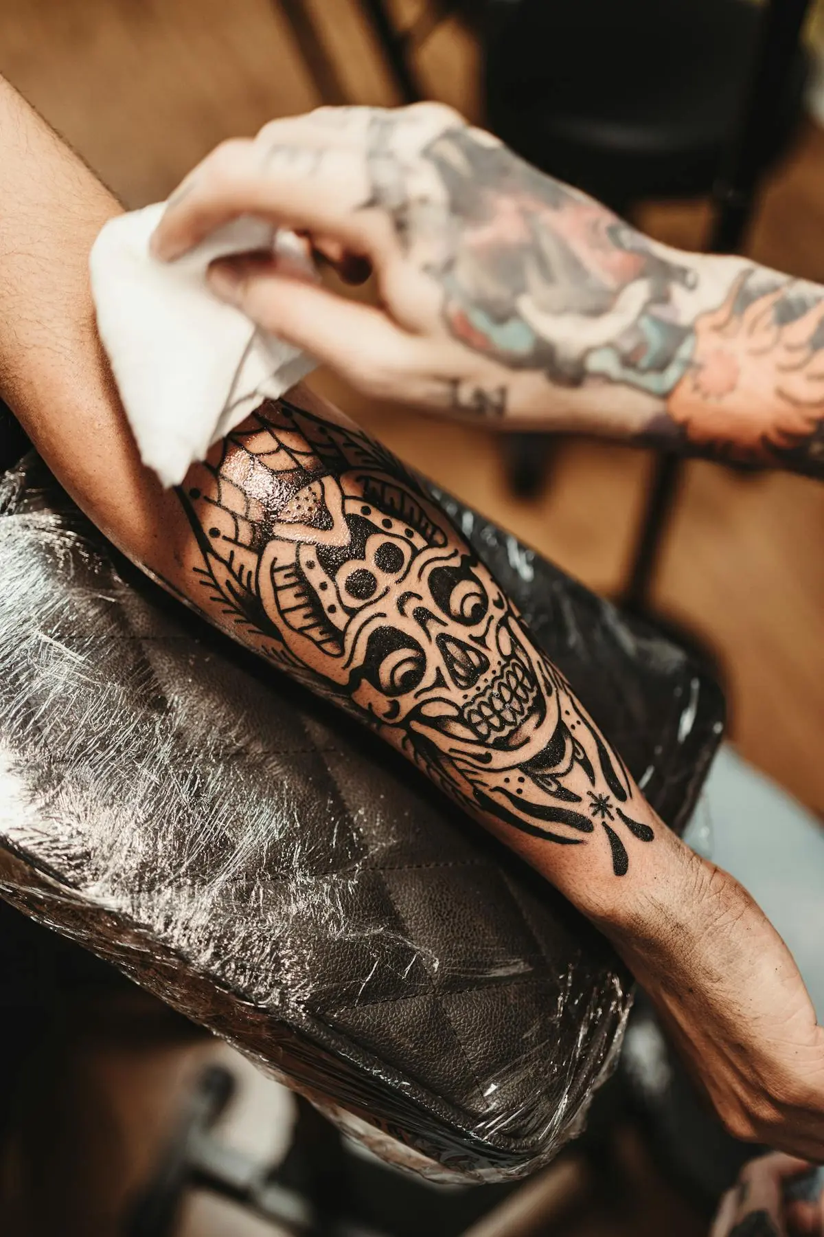 Bold solid-black traditional skull blackwork on the forearm