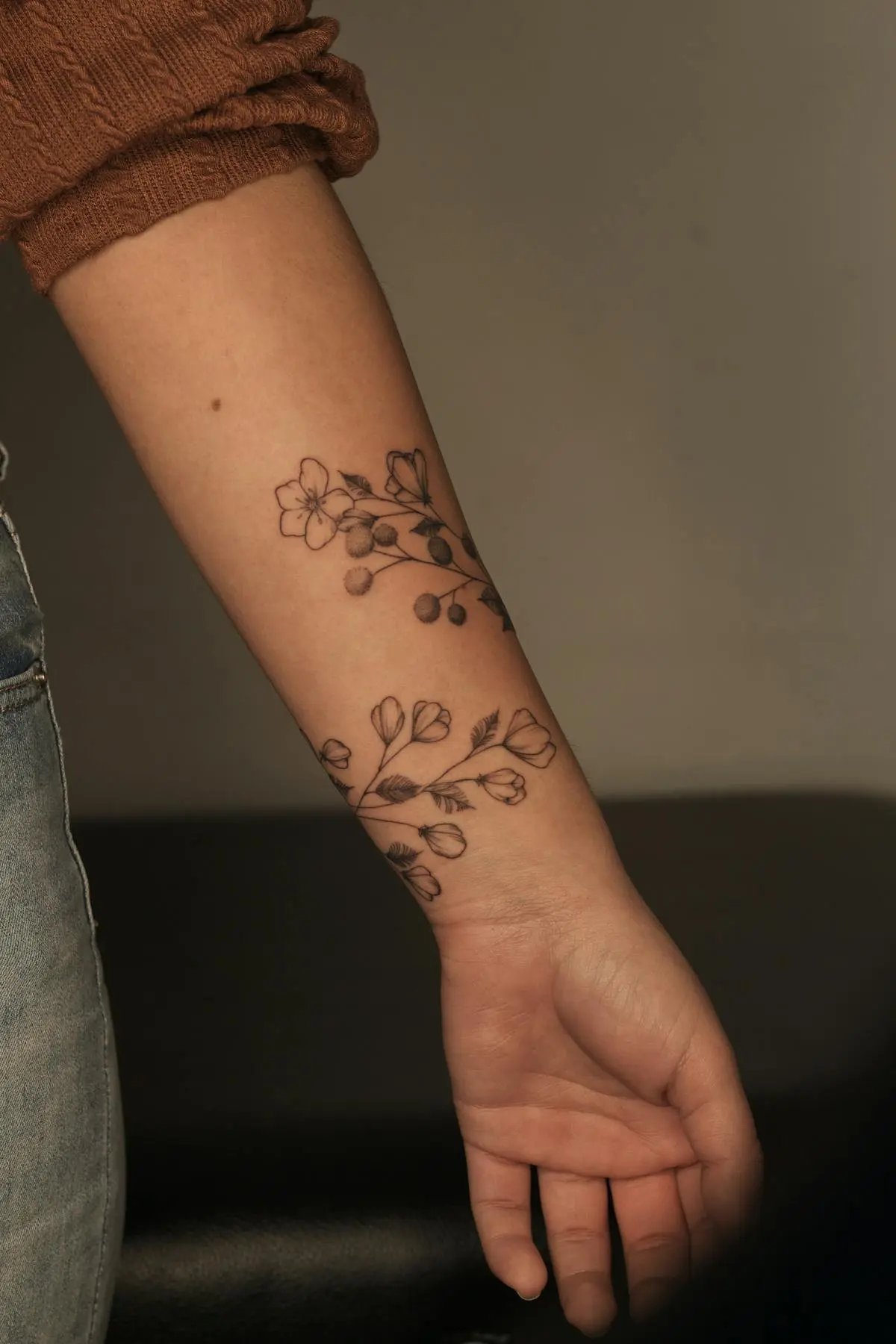 Fine-line wildflower wrap around the forearm and wrist