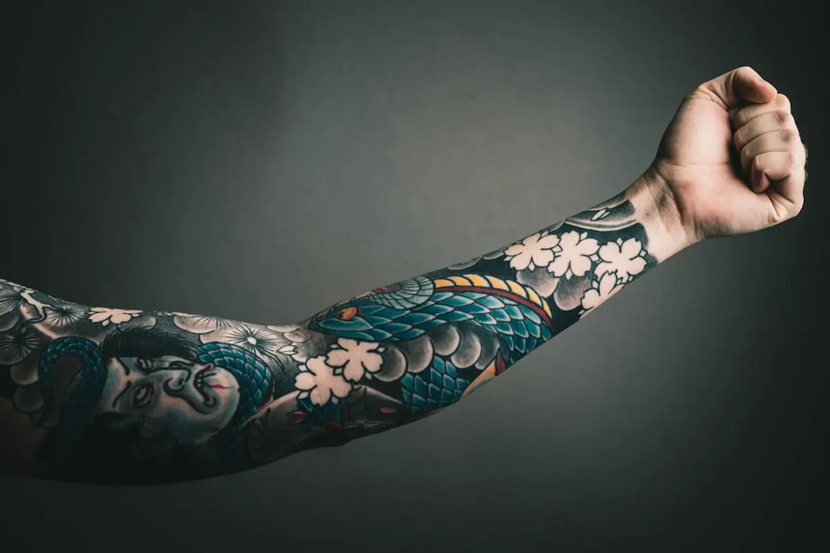 Blue koi and geisha sleeve with white cherry blossoms on the forearm