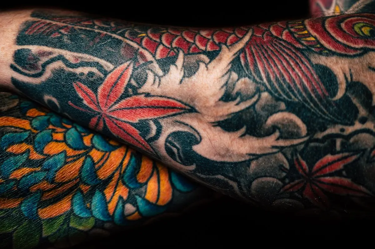 Close-up of koi, red maple leaves, and chrysanthemum on a black-and-color sleeve