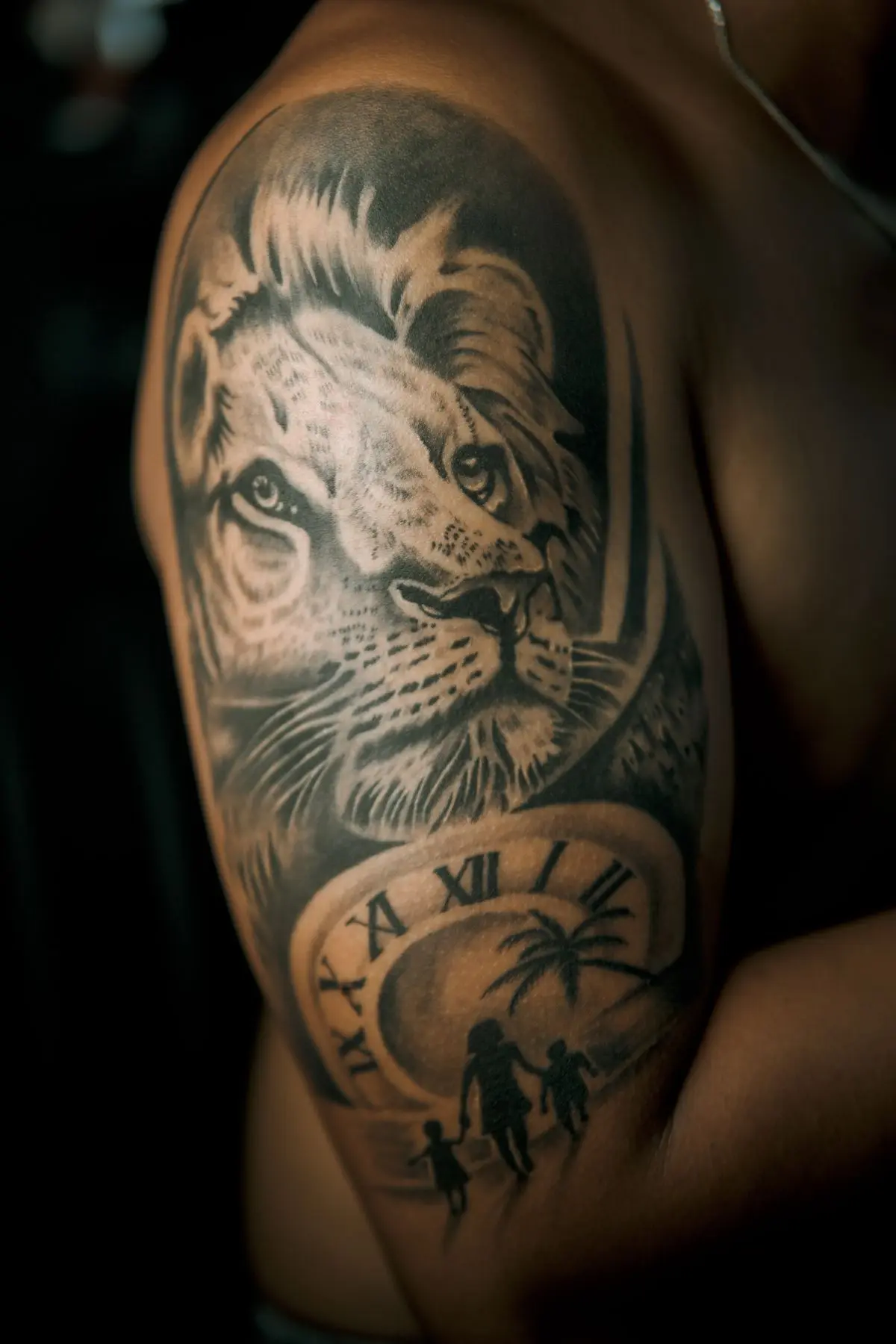 Photorealistic black-and-grey lion portrait with pocket watch and family silhouettes on the upper arm