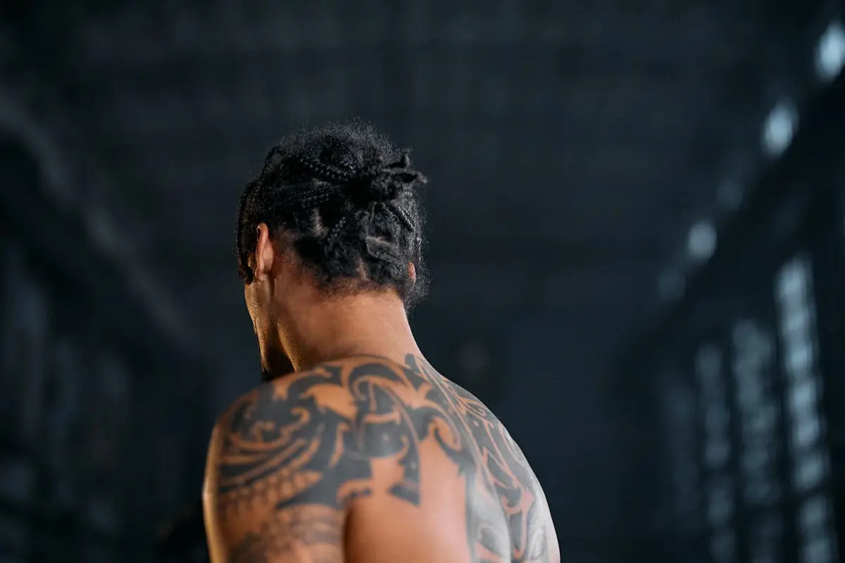 Bold black curvilinear tribal motif across the shoulder and upper back